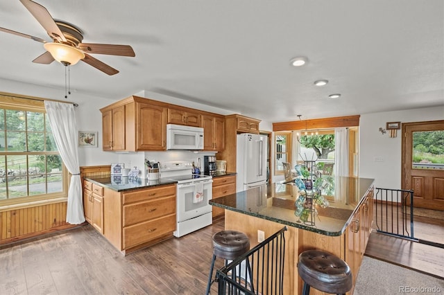 1233 Starling Ln, Elizabeth, CO 80107 - kitchen with white appliances, dark wood finished floors, recessed lighting, ceiling fan, and a breakfast bar