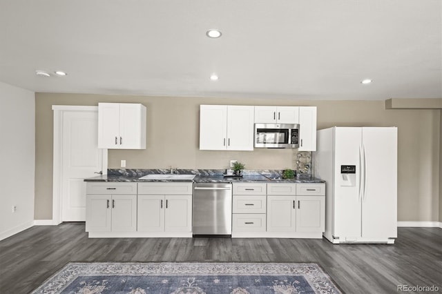 1233 Starling Ln, Elizabeth, CO 80107 - kitchen featuring appliances with stainless steel finishes, dark wood-style floors, dark countertops, white cabinetry, and recessed lighting