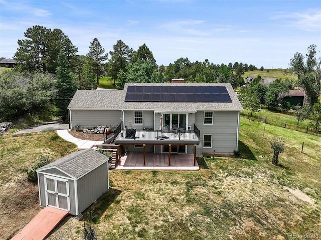 1233 Starling Ln, Elizabeth, CO 80107 - rear view of property featuring a wooden deck, a shed, a yard, and roof mounted solar panels