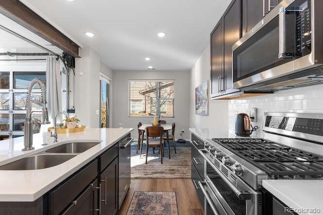 kitchen with decorative backsplash, sink, appliances with stainless steel finishes, and dark hardwood / wood-style floors