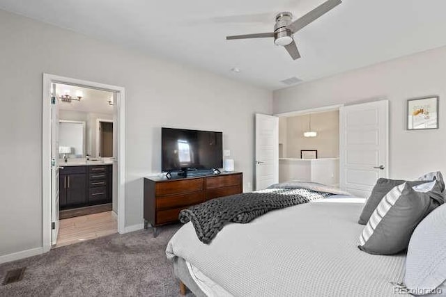 bedroom featuring ceiling fan, light colored carpet, and ensuite bathroom