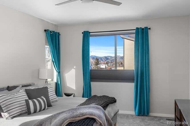 bedroom with ceiling fan, carpet floors, and a mountain view