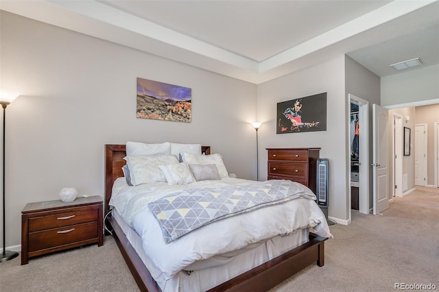 bedroom with baseboards, visible vents, light colored carpet, a spacious closet, and a closet