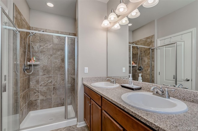 bathroom with a stall shower, a sink, and double vanity