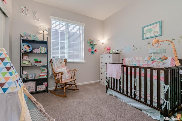 bedroom featuring a crib, carpet, and baseboards