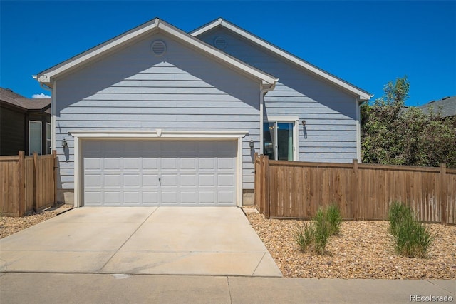 view of front of home featuring concrete driveway, fence, and an attached garage