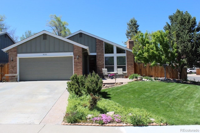 8101 S San Juan Range Rd, Littleton, CO 80127 - view of front of house featuring board and batten siding, an attached garage, concrete driveway, a chimney, and brick siding