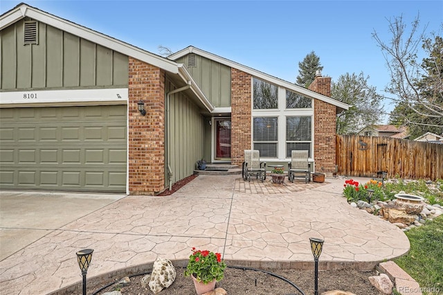 8101 S San Juan Range Rd, Littleton, CO 80127 - mid-century modern home featuring a chimney, a garage, board and batten siding, and concrete driveway