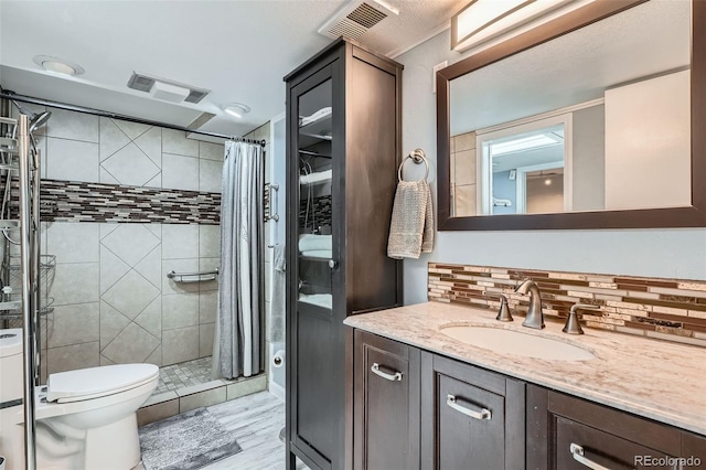 8101 S San Juan Range Rd, Littleton, CO 80127 - full bathroom featuring vanity, toilet, decorative backsplash, and a stall shower
