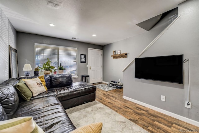 living area featuring visible vents, baseboards, wood finished floors, and recessed lighting