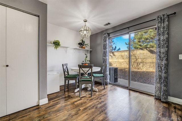 dining room featuring baseboards, visible vents, a chandelier, and dark wood-type flooring