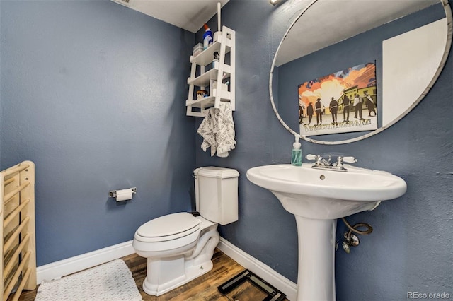 bathroom with wood finished floors, toilet, and baseboards