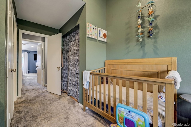 bedroom with a crib and carpet flooring