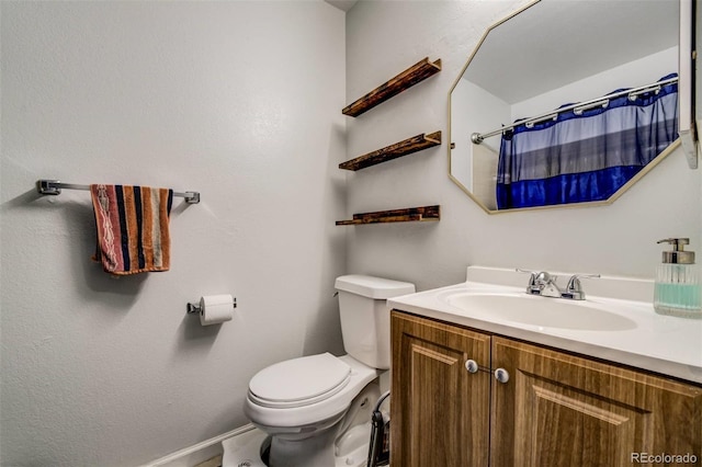 bathroom featuring toilet, a shower with shower curtain, and vanity