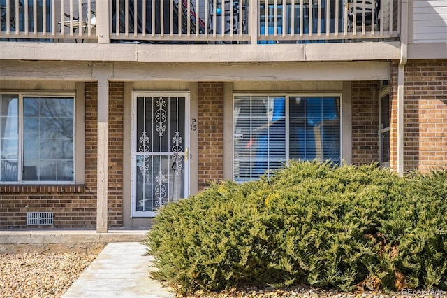 doorway to property featuring brick siding and crawl space