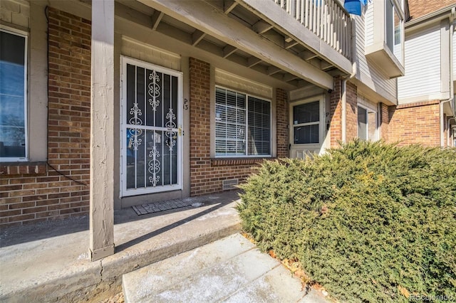 doorway to property with brick siding