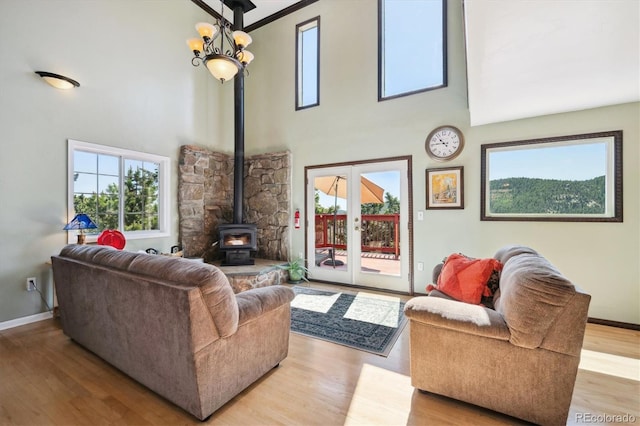 32392 Lodgepole Dr, Evergreen, CO 80439 - living area featuring a wood stove, a high ceiling, wood finished floors, plenty of natural light, and a chandelier
