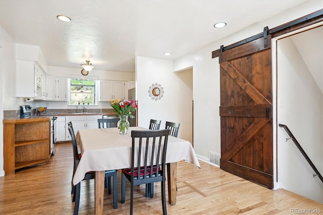 32392 Lodgepole Dr, Evergreen, CO 80439 - dining space featuring a barn door, light wood-style flooring, and recessed lighting