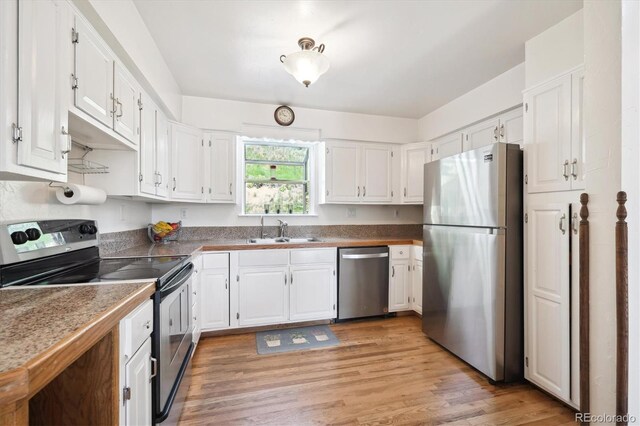32392 Lodgepole Dr, Evergreen, CO 80439 - kitchen with appliances with stainless steel finishes, white cabinets, and light wood-type flooring