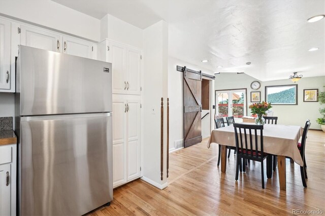 32392 Lodgepole Dr, Evergreen, CO 80439 - dining space featuring a barn door, light wood-type flooring, and recessed lighting