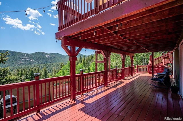32392 Lodgepole Dr, Evergreen, CO 80439 - wooden terrace featuring a view of trees, a mountain view, and area for grilling