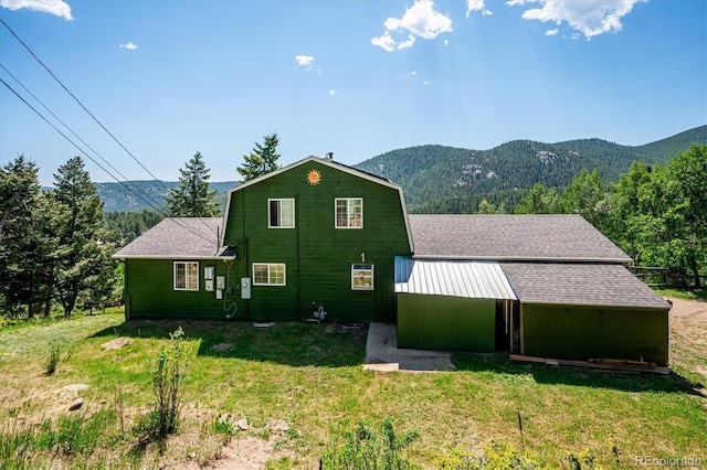 32392 Lodgepole Dr, Evergreen, CO 80439 - view of front facade featuring a mountain view, a front lawn, and a shingled roof
