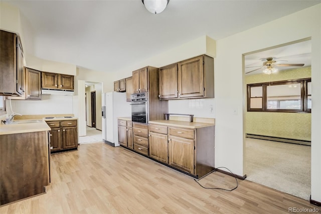 65 Yeoman Ln, Divide, CO 80814 - kitchen featuring baseboard heating, white refrigerator with ice dispenser, a sink, ceiling fan, and oven