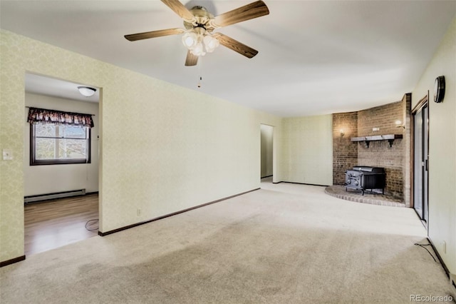 65 Yeoman Ln, Divide, CO 80814 - unfurnished living room with a baseboard heating unit, a wood stove, light carpet, ceiling fan, and baseboards