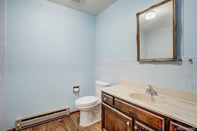 65 Yeoman Ln, Divide, CO 80814 - bathroom with a baseboard radiator, toilet, vanity, tile walls, and wood finished floors