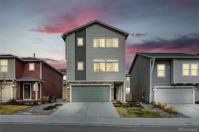 view of front of home featuring a garage, stone siding, and concrete driveway