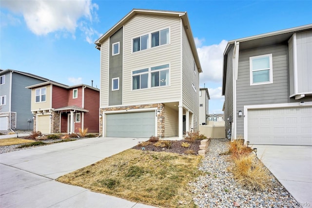 view of front facade featuring concrete driveway, an attached garage, and stone siding