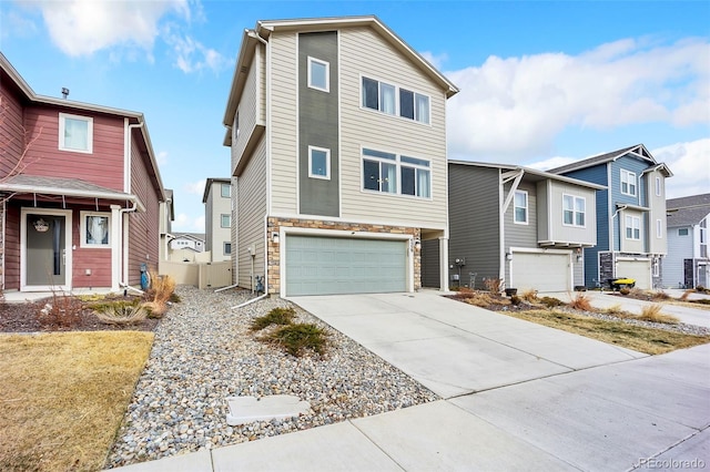 townhome / multi-family property featuring an attached garage, a residential view, stone siding, and driveway