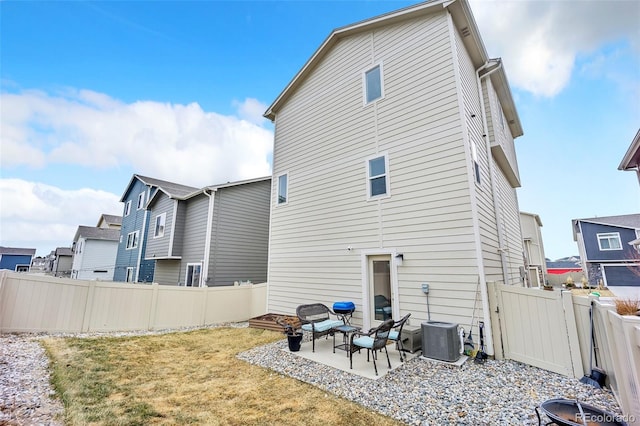 back of property with a patio, a lawn, central AC unit, and a fenced backyard