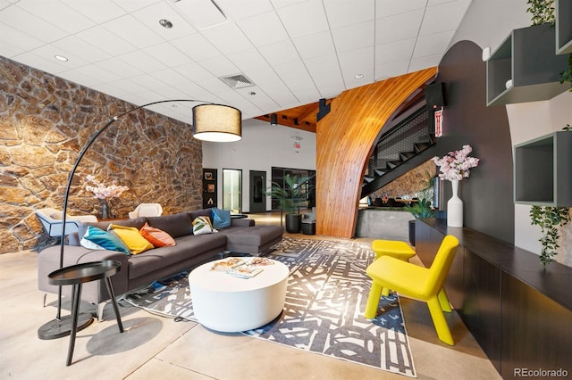 living room with stairway, a paneled ceiling, and visible vents