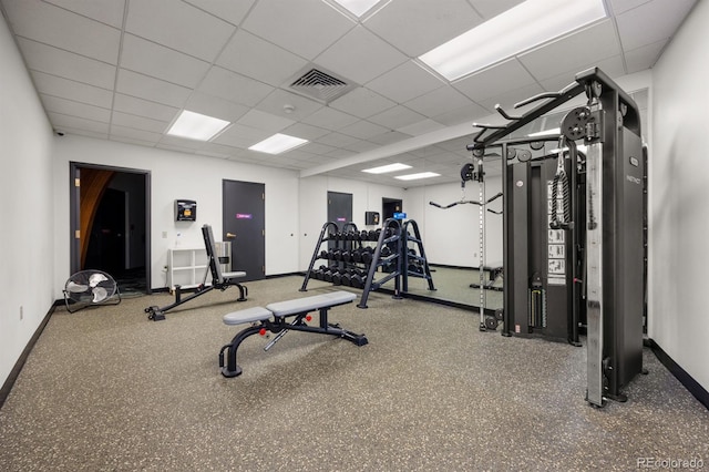 workout area featuring a paneled ceiling, visible vents, and baseboards