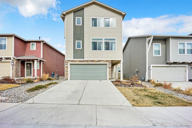 view of front facade featuring concrete driveway, an attached garage, and stone siding