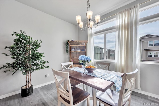 dining room featuring a chandelier, baseboards, and light wood-style flooring