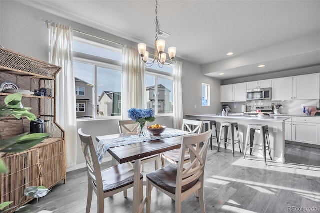 dining area with visible vents, recessed lighting, light wood finished floors, baseboards, and a chandelier