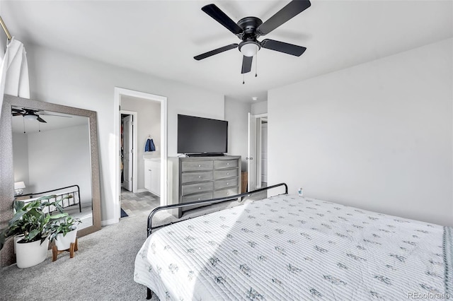 carpeted bedroom with ensuite bath, baseboards, and ceiling fan