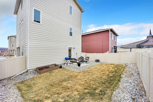 rear view of house featuring a patio area, a lawn, and a fenced backyard