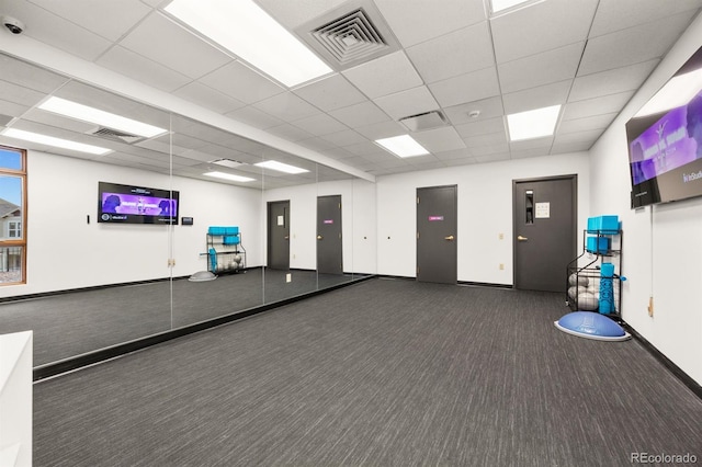 interior space with visible vents, a paneled ceiling, and baseboards