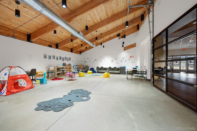 interior space featuring wood ceiling, beam ceiling, high vaulted ceiling, and concrete floors