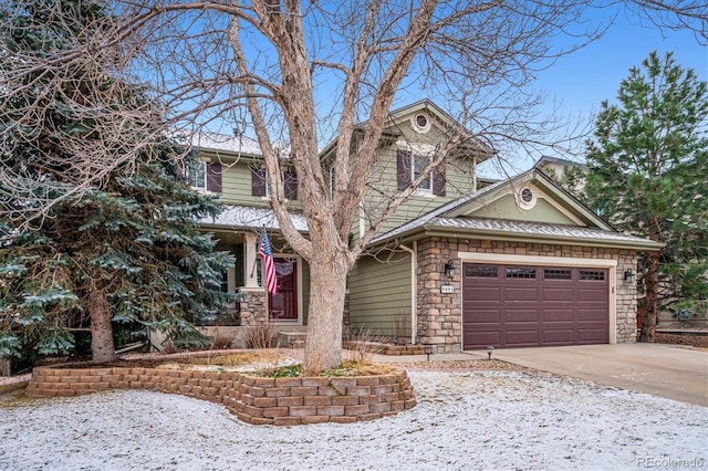 view of front of property featuring driveway, stone siding, and a garage