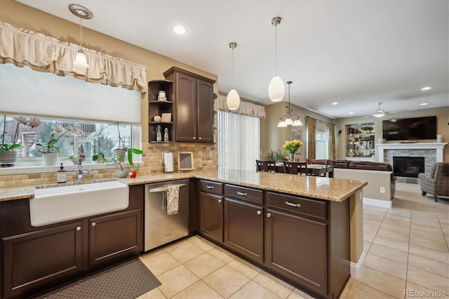 kitchen with backsplash, stainless steel dishwasher, a sink, dark brown cabinets, and a peninsula