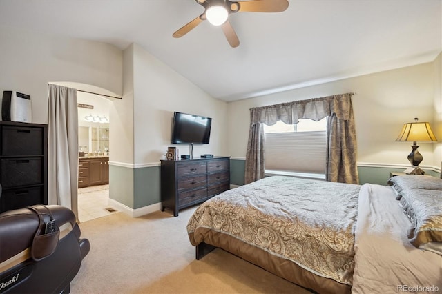 bedroom featuring lofted ceiling, ceiling fan, connected bathroom, light colored carpet, and baseboards