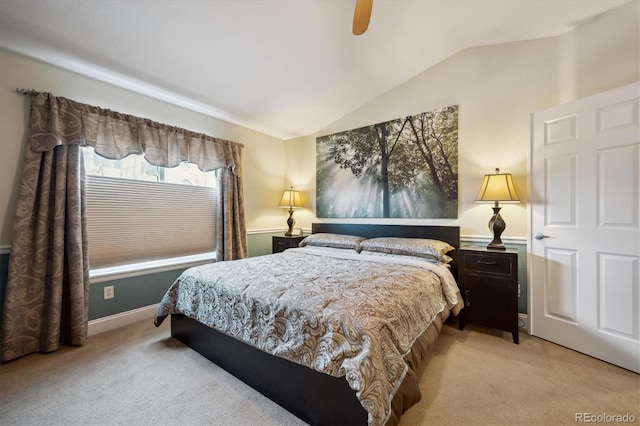 bedroom with baseboards, vaulted ceiling, a ceiling fan, and light colored carpet