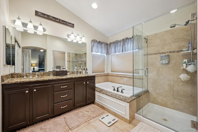 full bath featuring a garden tub, a sink, vaulted ceiling, a shower stall, and double vanity