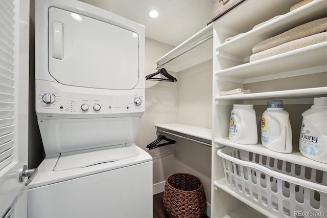 laundry room with laundry area, wood finished floors, stacked washer and clothes dryer, and recessed lighting