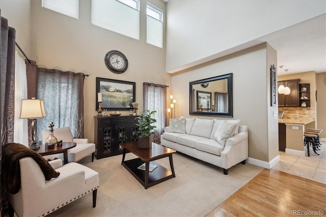9882 S Hoyt Ct, Littleton, CO 80127 - living area with a high ceiling, light wood finished floors, and baseboards