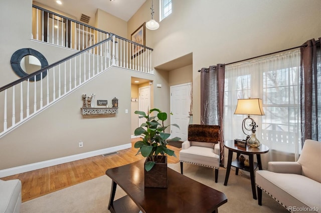 9882 S Hoyt Ct, Littleton, CO 80127 - living area featuring baseboards, stairway, wood finished floors, and a high ceiling